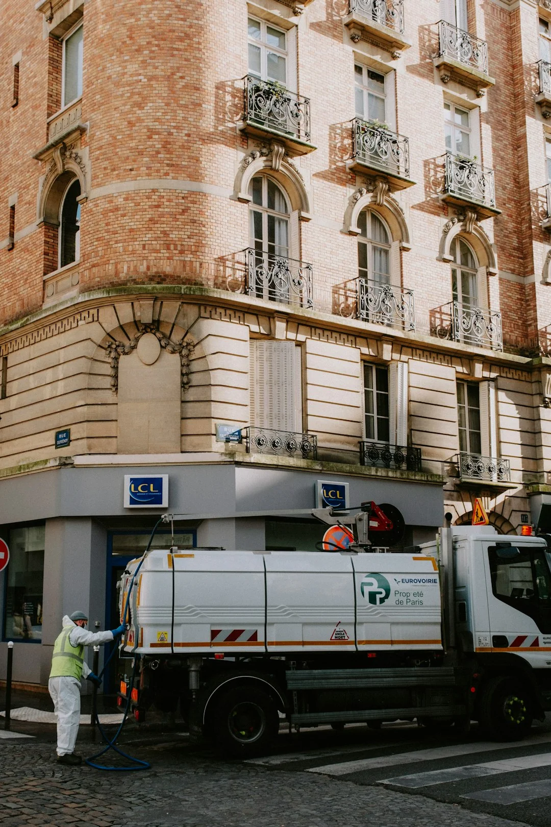 Vue de profil d’un jeune employé tenant une pile de serviettes blanches dans la salle de bain d’un hôtel de luxe